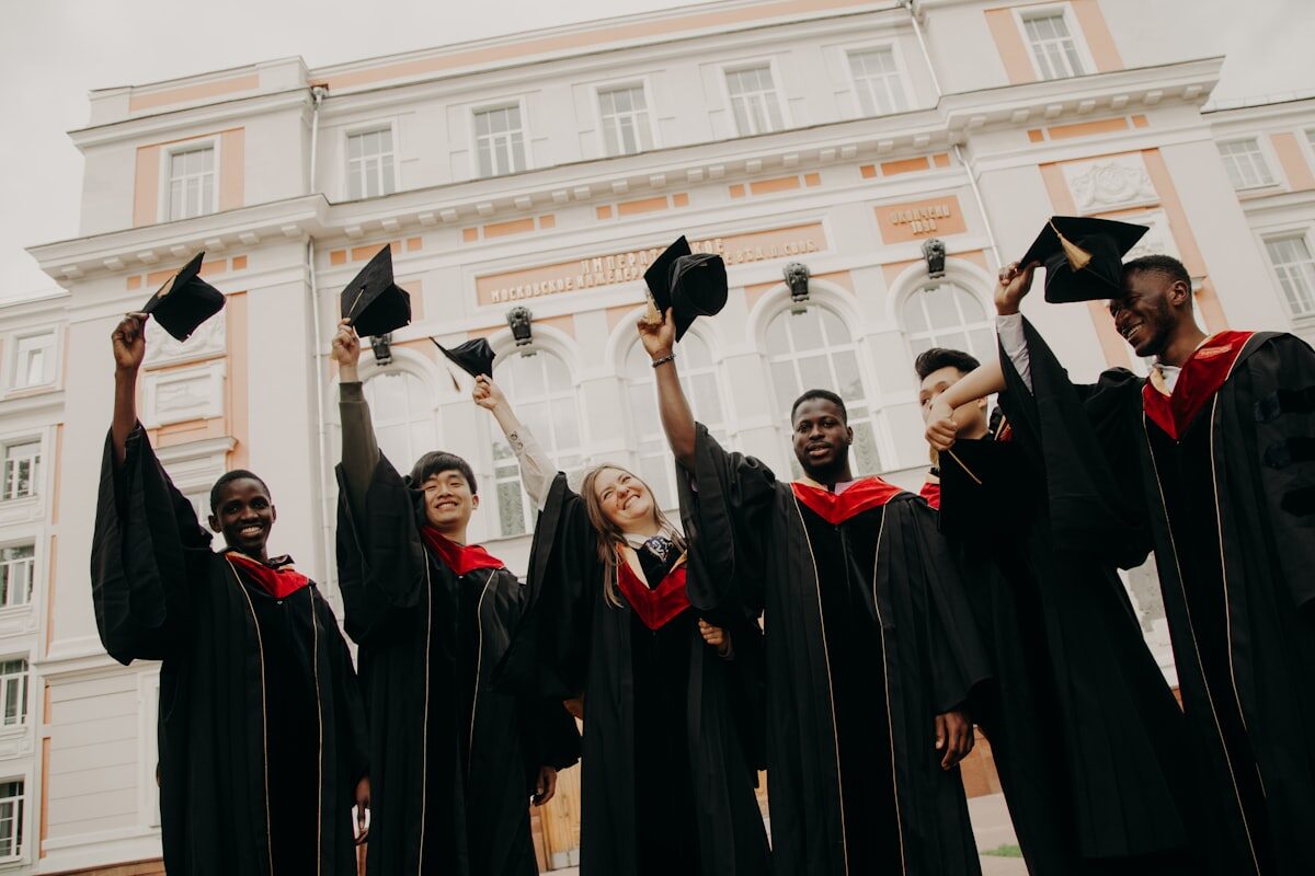 A diverse class of graduates celebrating at a university abroad